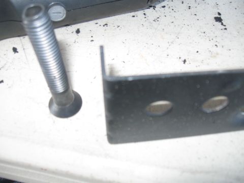 1991 Ford Bronco - A bolt and a metal bracket are shown in this close-up image.