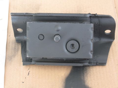 1991 Ford Bronco - A black motor mount part is shown against a cardboard background.