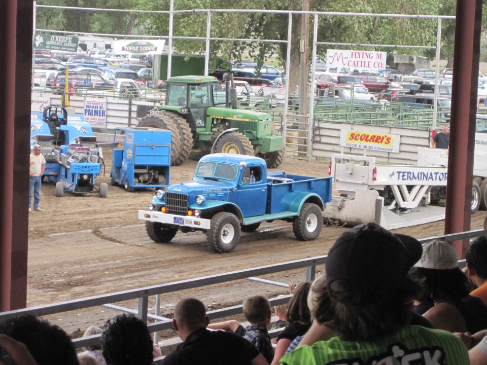Blue vintage Dodge Power Wagon pickup on a dirt track at a fairground truck pull