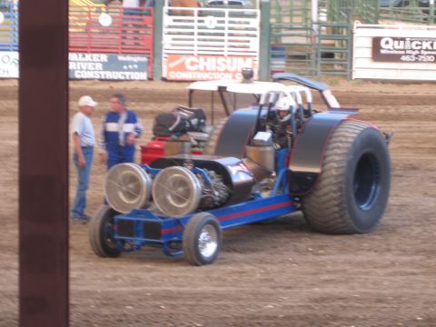 1989 Ford Bronco - A modified tractor puller with a driver in the seat sits on a dirt track.