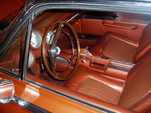 1995 Mercury Grand Marquis - The interior of this classic car features a wood-rimmed steering wheel and distinctive orange upholstery.