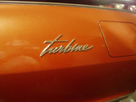 1995 Mercury Grand Marquis - Close-up of a "Turbine" emblem on an orange vehicle part.