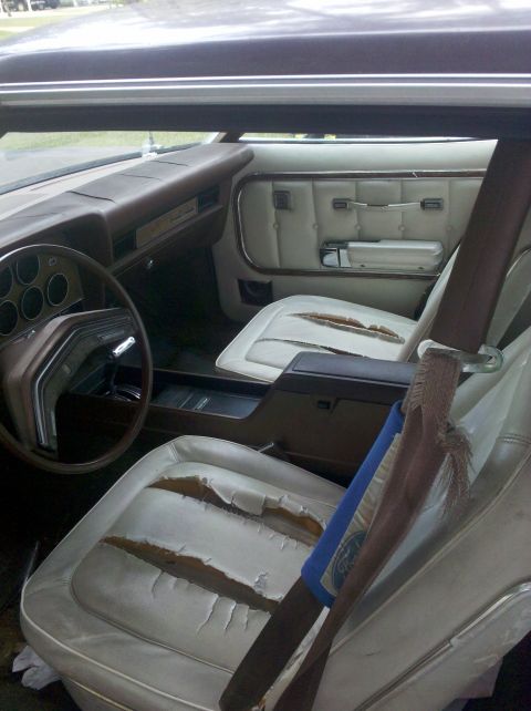 1974 Ford Elite - Interior view of a 1974 Ford Elite, highlighting the worn white seats and dashboard details.