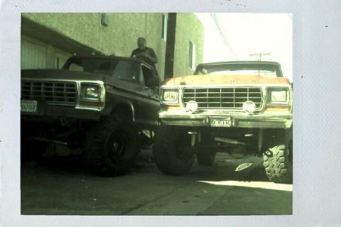 1978 Ford Bronco - Two lifted Ford trucks are parked next to each other, showing their front ends.