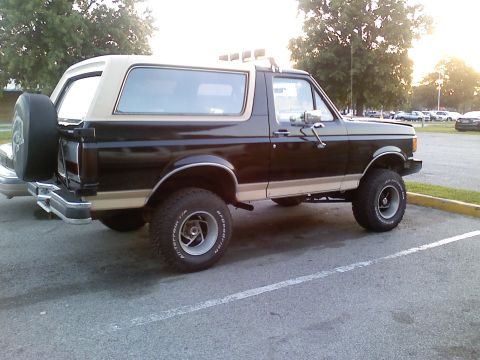 1990 Ford Bronco - This 1990 Ford Bronco features a two-tone black and tan paint scheme and a rear-mounted spare tire.