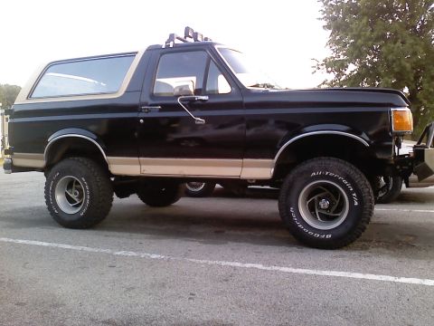 1990 Ford Bronco - Side view of a black 1990 Ford Bronco with tan trim and BFGoodrich All-Terrain T/A tires.
