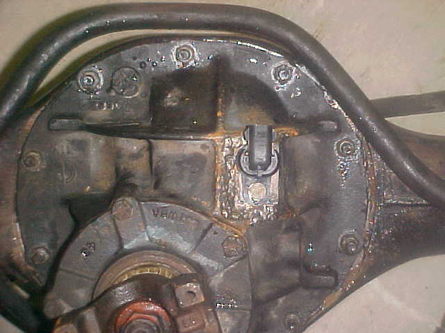 Rear axle differential housing with visible rust and a black U-shaped sensor