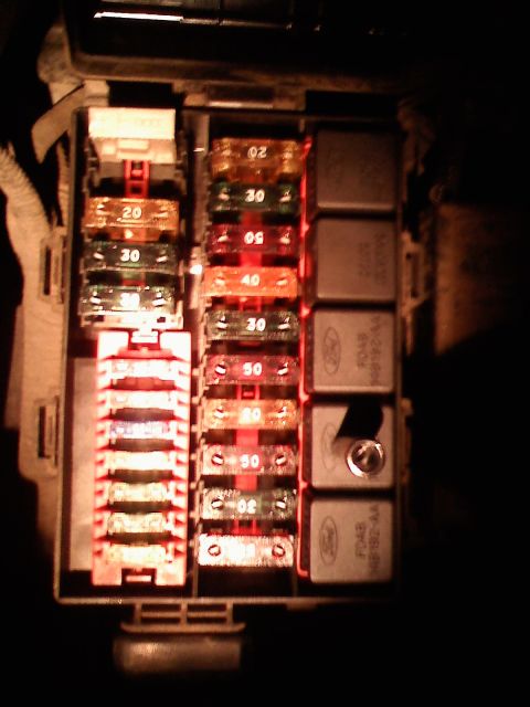 1996 Ford Bronco - A close-up view of a vehicle's fuse box reveals various fuses and relays.
