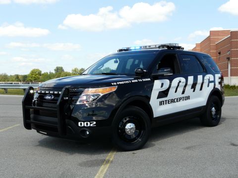 1993 Ford Taurus - A black Ford Police Interceptor SUV is parked on asphalt under a partly cloudy sky.