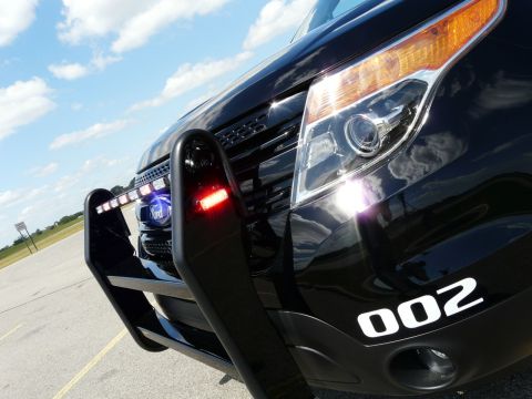 1993 Ford Taurus - Front view of a black police SUV with a push bar and emergency lights, displaying the number 002.