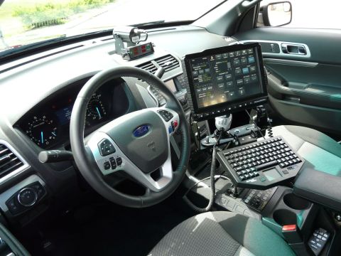 1993 Ford Taurus - Interior view of a modern police vehicle, a large command touchscreen, keyboard, and Ford steering wheel.