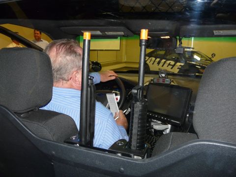 1993 Ford Taurus - Interior of a police vehicle with mounted rifles and a second police car in the background.