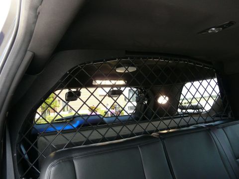 1993 Ford Taurus - Rear interior of a police vehicle, equipped with a protective partition and rear seats.