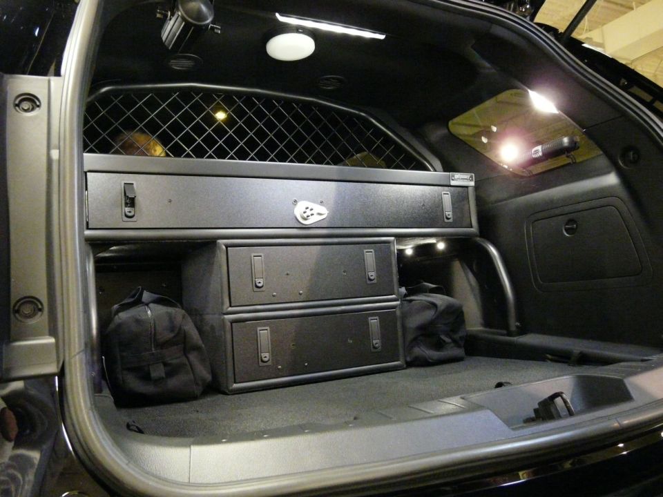 SUV cargo area with black metal drawer storage system and rear cage partition