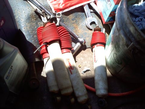 1996 Ford F-150 - Several Rancho RS 5000 shock absorbers are laid out with tools and automotive fluids.