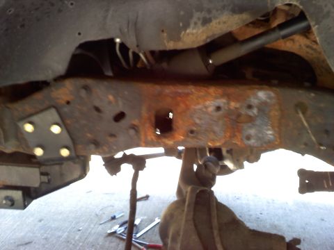 1996 Ford F-150 - Close-up view of a corroded vehicle frame and undercarriage components.