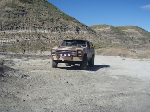 1985 Ford Bronco - This Ford Bronco, painted in a desert camouflage pattern, sits parked in a , arid environment under a clear blue sky.