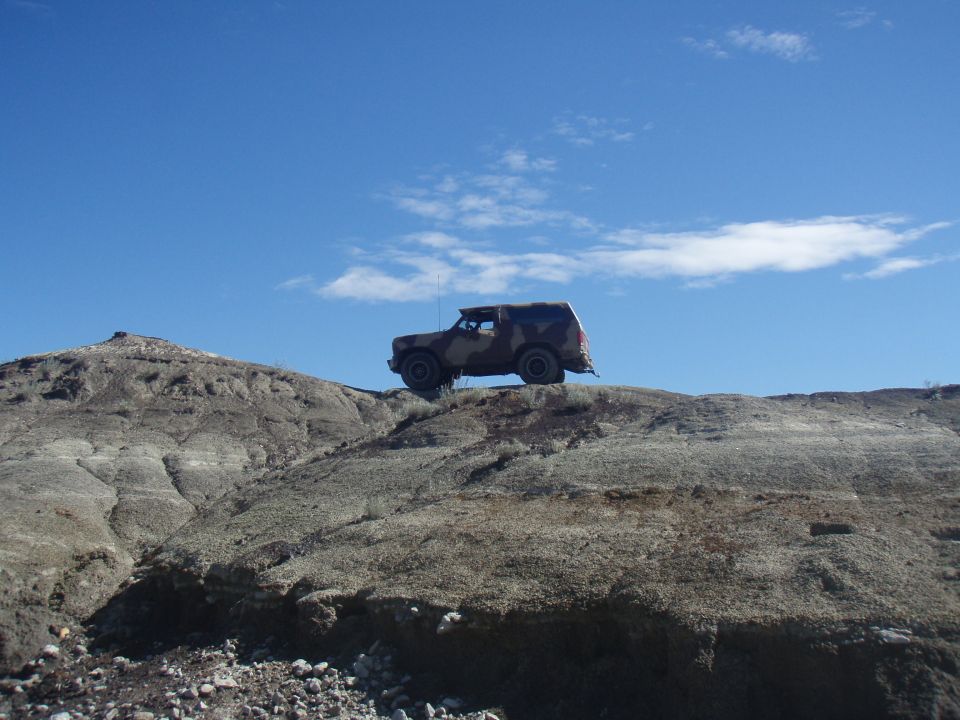 1985 Ford Bronco on a rocky hill under a blue sky