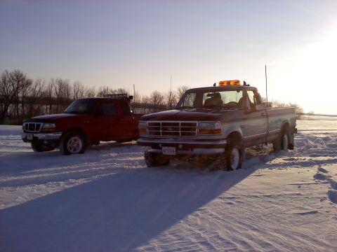 1996 Ford F-150 - Two pickup trucks, a 1996 Ford F-150 and a red Ford Ranger, sit in a snowy field.