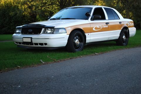 1998 Ford Crown Victoria - A 1998 Ford Crown Victoria taxi, identified by its distinctive body style, is parked on the side of a road.