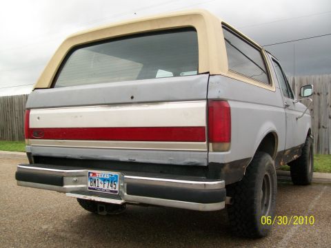 1990 Ford Bronco - The rear of a 1990 Ford Bronco shows its two-tone paint scheme with a tan removable top.