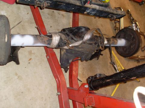 1985 Jeep CJ7 - Rear axle assembly supported by a red stand, with a visible Supermotors.net logo.