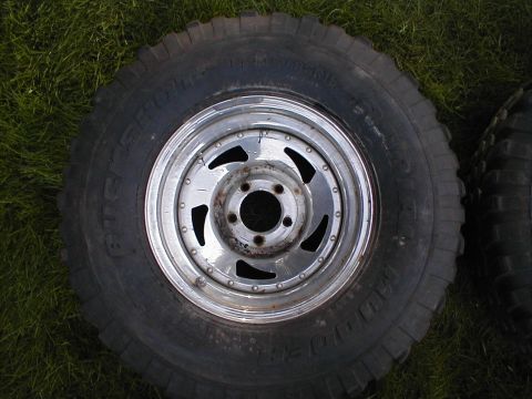 1980 Ford Bronco - A single tire and rim assembly is shown, resting on a grassy surface.