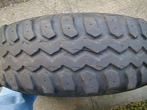 1980 Ford Bronco - Close-up of a worn tire, showing its tread design and signs of age.