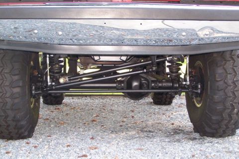 1990 Ford Bronco - The underside of a modified 4x4 vehicle is shown, focusing on the rear axle and suspension system.
