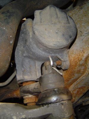 1995 Ford Bronco - Close-up view of a steering gear box and tie rod end, showing mechanical components.
