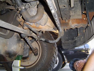 1995 Ford Bronco - Close-up of steering and suspension components underneath a vehicle.