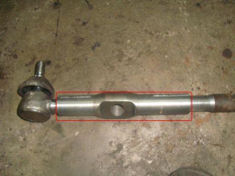 1996 Ford Bronco - A metal tie rod end component is shown against a concrete surface.