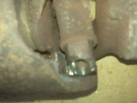 1991 Ford Bronco - A close-up view of a damaged driveshaft, showing significant rust and wear on its components.