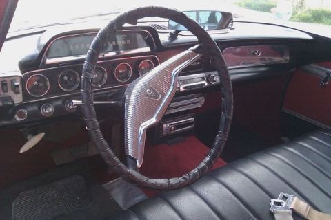 1991 Ford Crown Victoria - The interior of a classic car shows a dashboard with multiple gauges and a chrome-detailed steering wheel.
