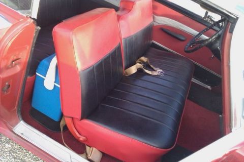 1991 Ford Crown Victoria - The interior of a classic car features two-tone red and black seats with a seatbelt and a blue cooler in the back.
