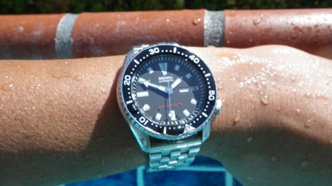 1996 Ford Bronco - A close-up of a Seiko automatic watch on a wet wrist near a pool.