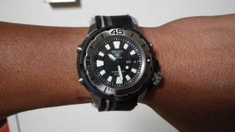 1996 Ford Bronco - Seiko 5 Sports automatic dive watch with black dial and fabric strap is worn on a wrist.