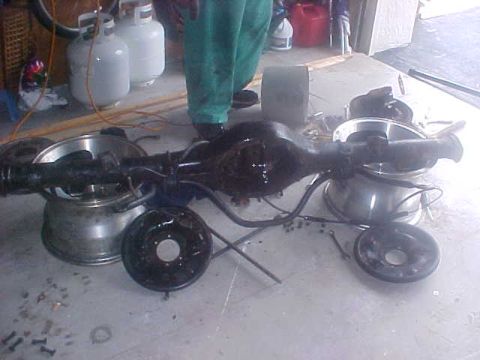 1996 Ford Bronco - A disassembled rear axle assembly is shown with brake drums and wheels, suggesting a repair or restoration project.