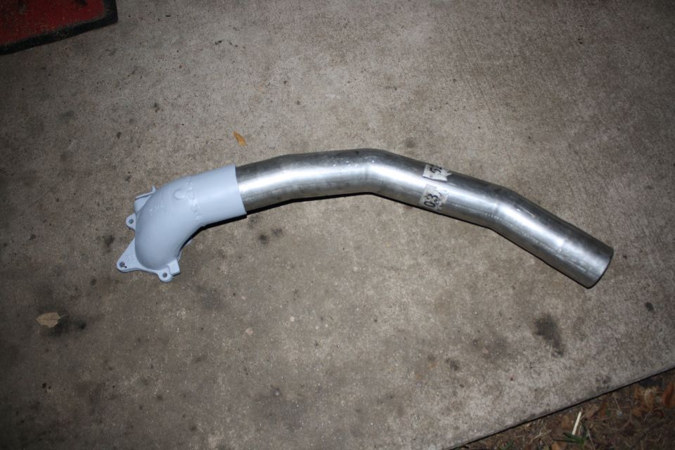 Exhaust pipe with a grey flange on a concrete surface