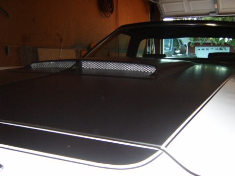 1973 Ford Ranchero - A car's hood with prominent air scoops is shown, with another vehicle visible in the background.