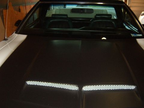 1973 Ford Ranchero - A 1973 Ford Ranchero with a black hood and white body is shown from a front three-quarter angle.