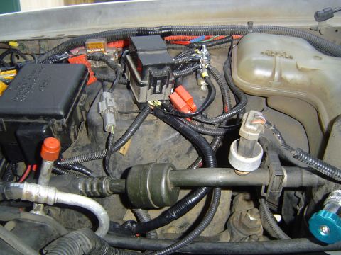 1994 Ford Crown Victoria - Close-up of engine bay wiring and components, including fuse boxes and a coolant reservoir.