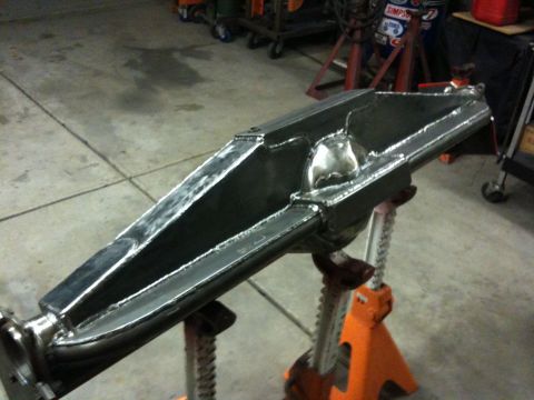 Suzuki Samurai - A fabricated metal axle housing is supported by orange jack stands in a workshop.