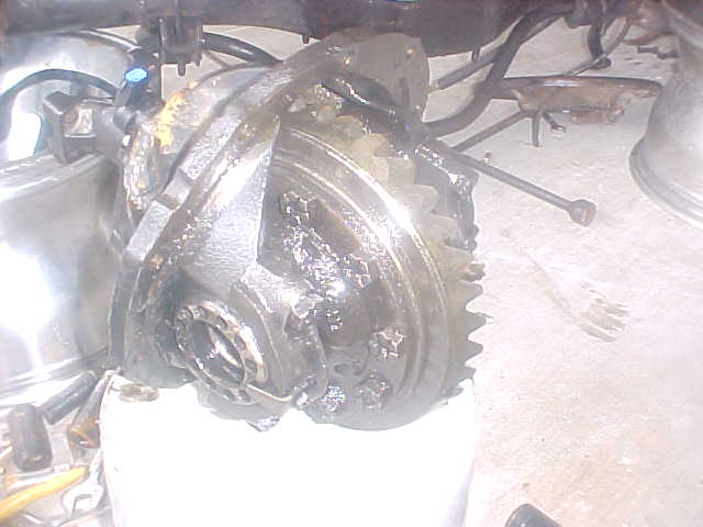 Close-up of a greasy differential gear assembly with visible teeth
