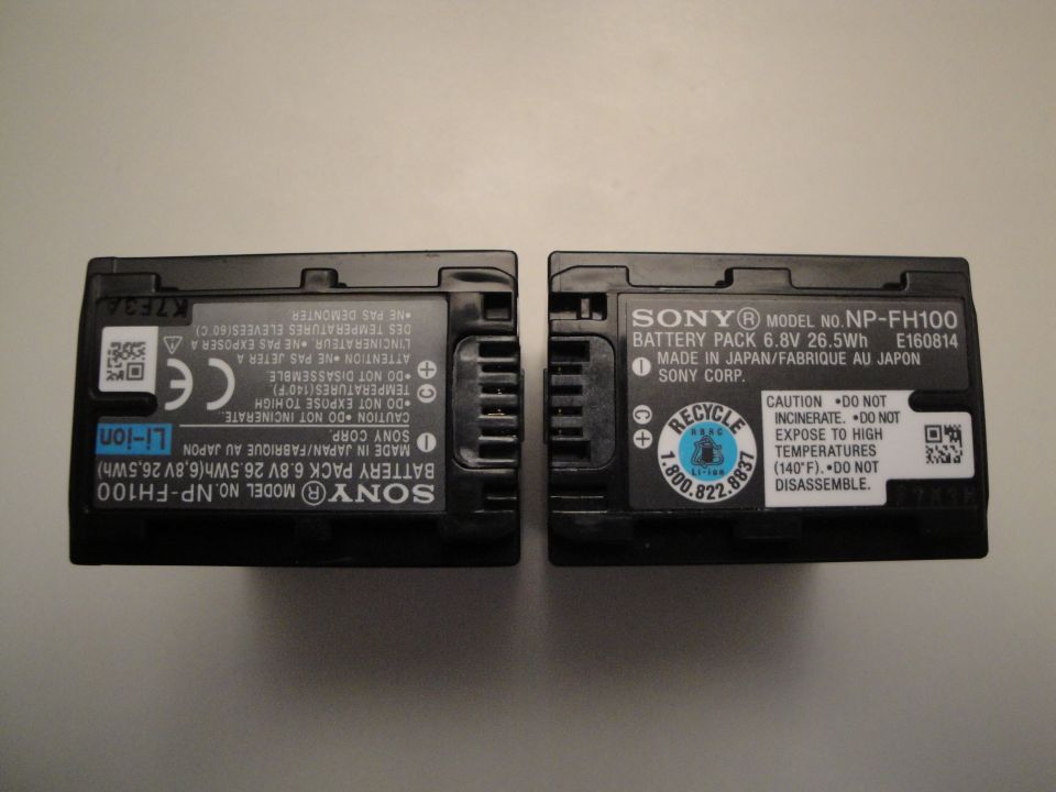 Two black Sony NP-FH100 battery packs side-by-side, showing labels with model numbers and warnings