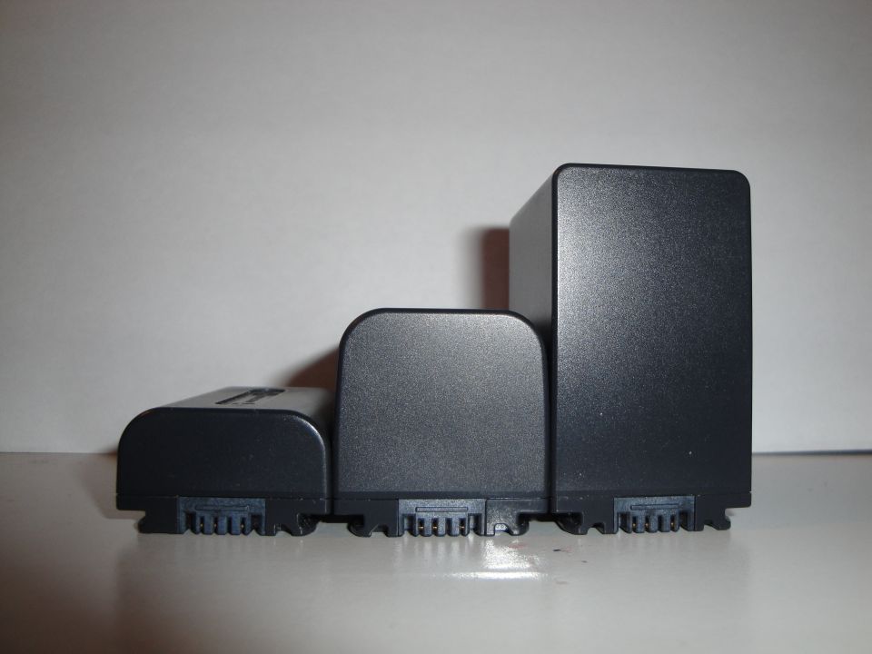 Three black camera batteries lined up by size