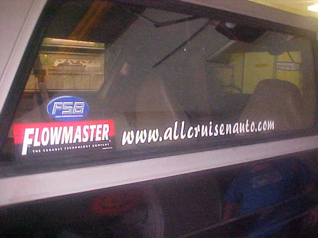Car window with Flowmaster and www.allcruisenauto.com stickers, and a Supermotors.net logo