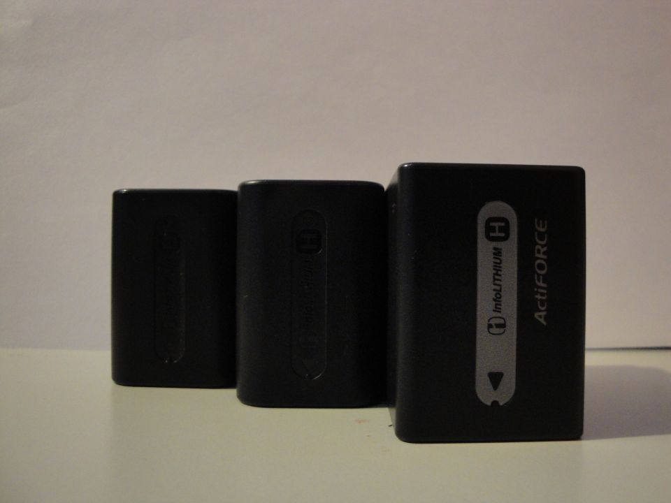 Three black camera batteries, one labeled ActiFORCE InfoLITHIUM H