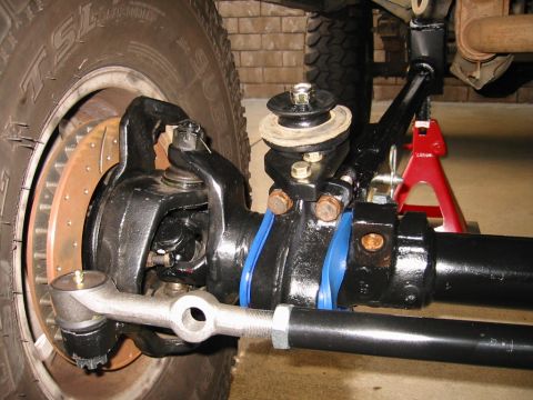 1985 Ford Bronco - Detailed view of off-road vehicle suspension and steering components, including a tire and brake assembly.