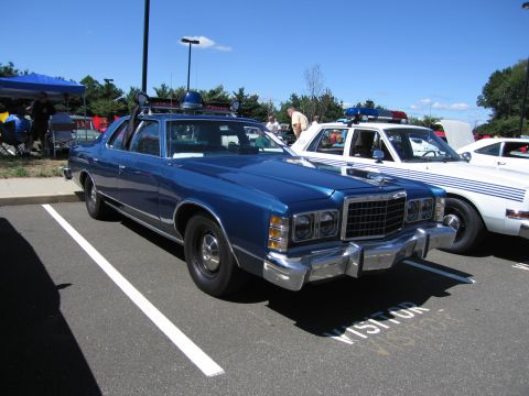 1991 Ford LTD Crown Victoria - blue 1970s Ford LTD two-door coupe with a roof spotlight parked at an outdoor car show.